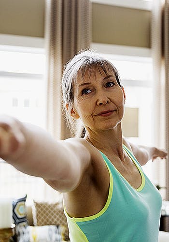 Close-up of middle aged woman stretching her arms