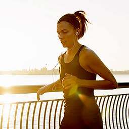 Young woman jogging and listening to music