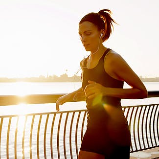 Young woman jogging and listening to music