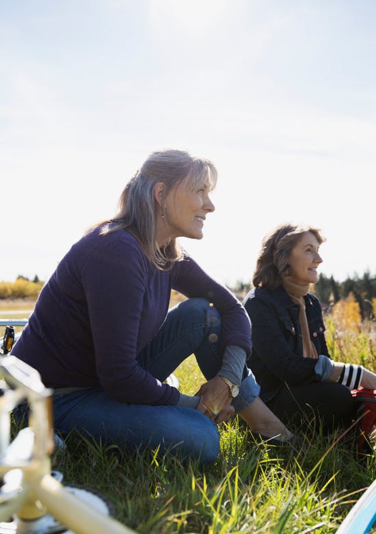 Defining body pain Two women sitting on the grass in a field