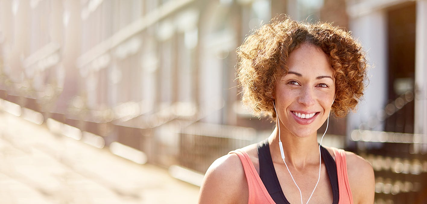 Woman smiling and listening to music with headphones