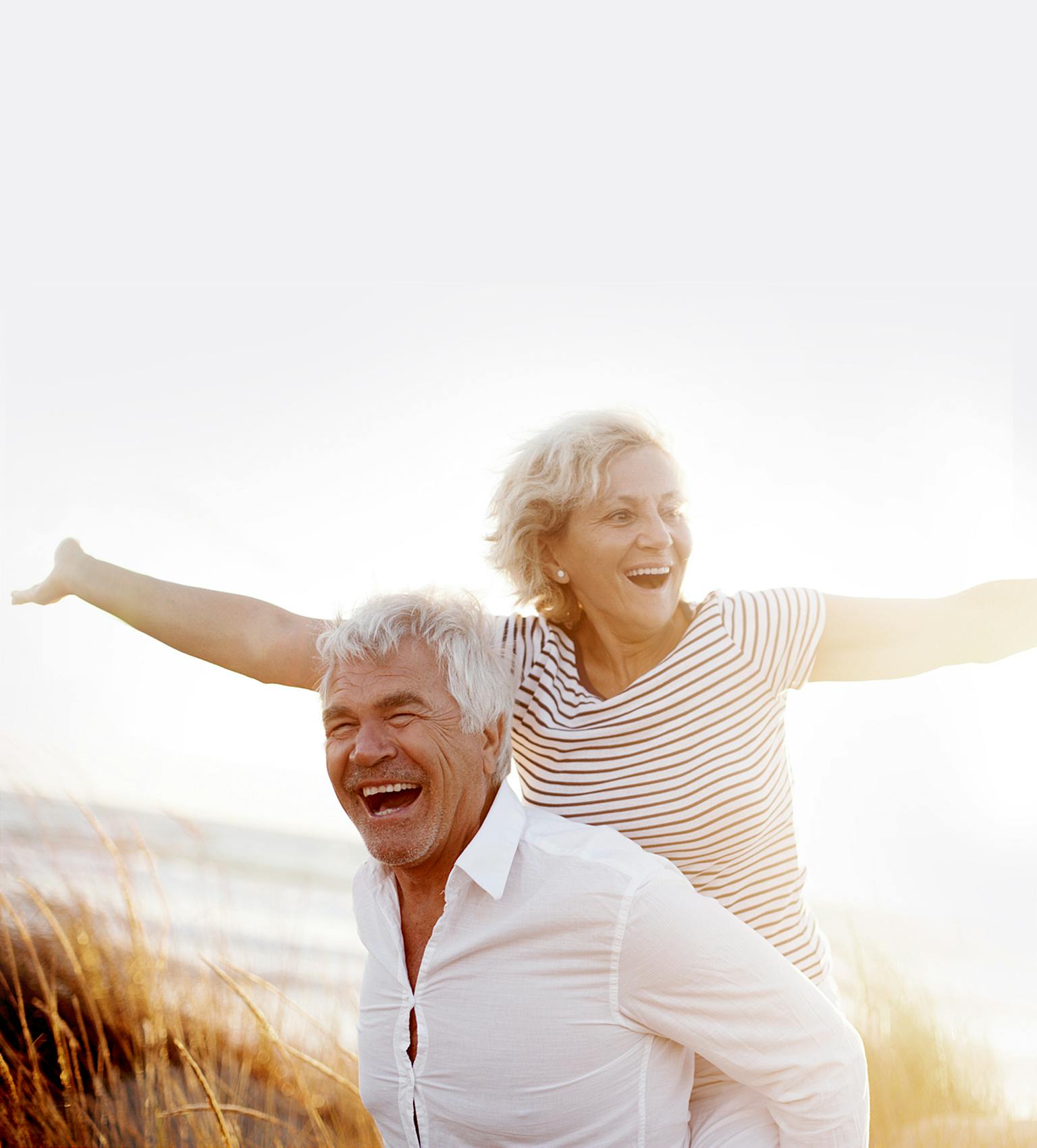 Older man giving his wife a piggyback ride