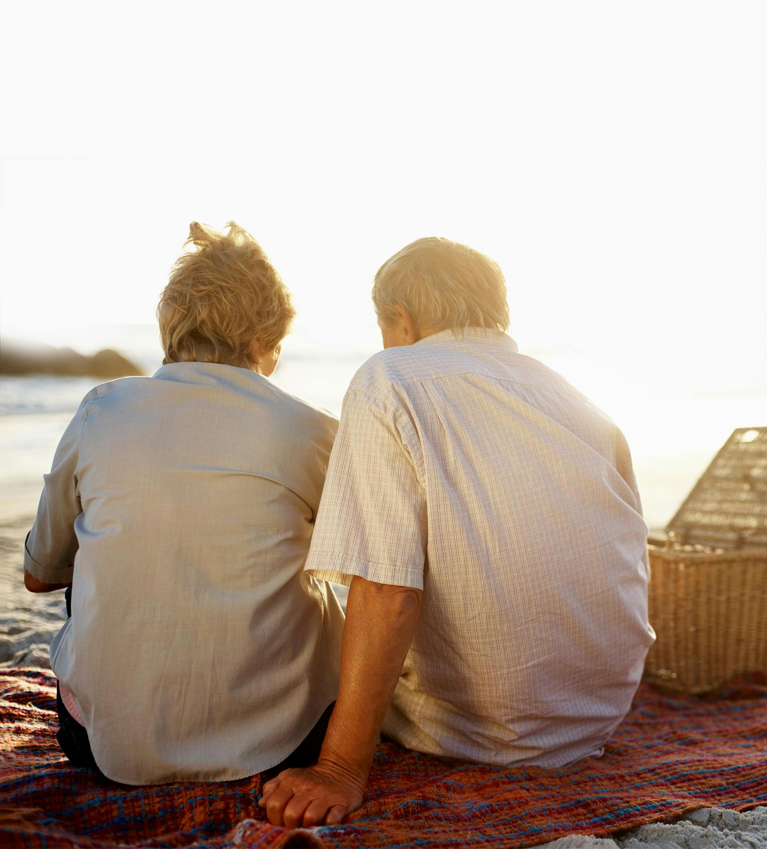 Aged couple sitting on a beach and enjoying the view of the sea