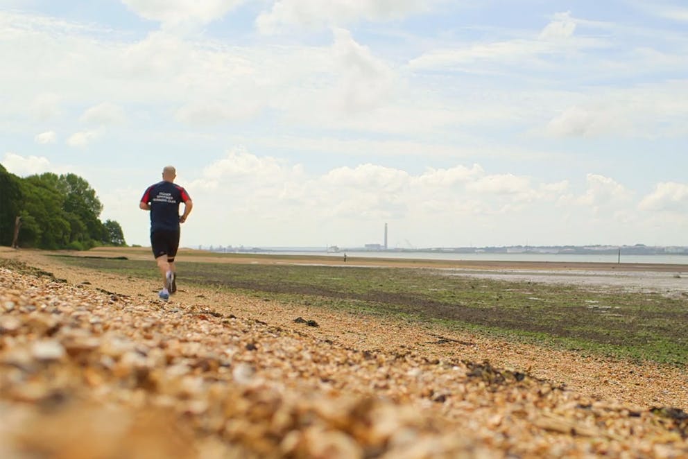 Homme qui fait du jogging sur une plage Homme qui fait du jogging sur une plage