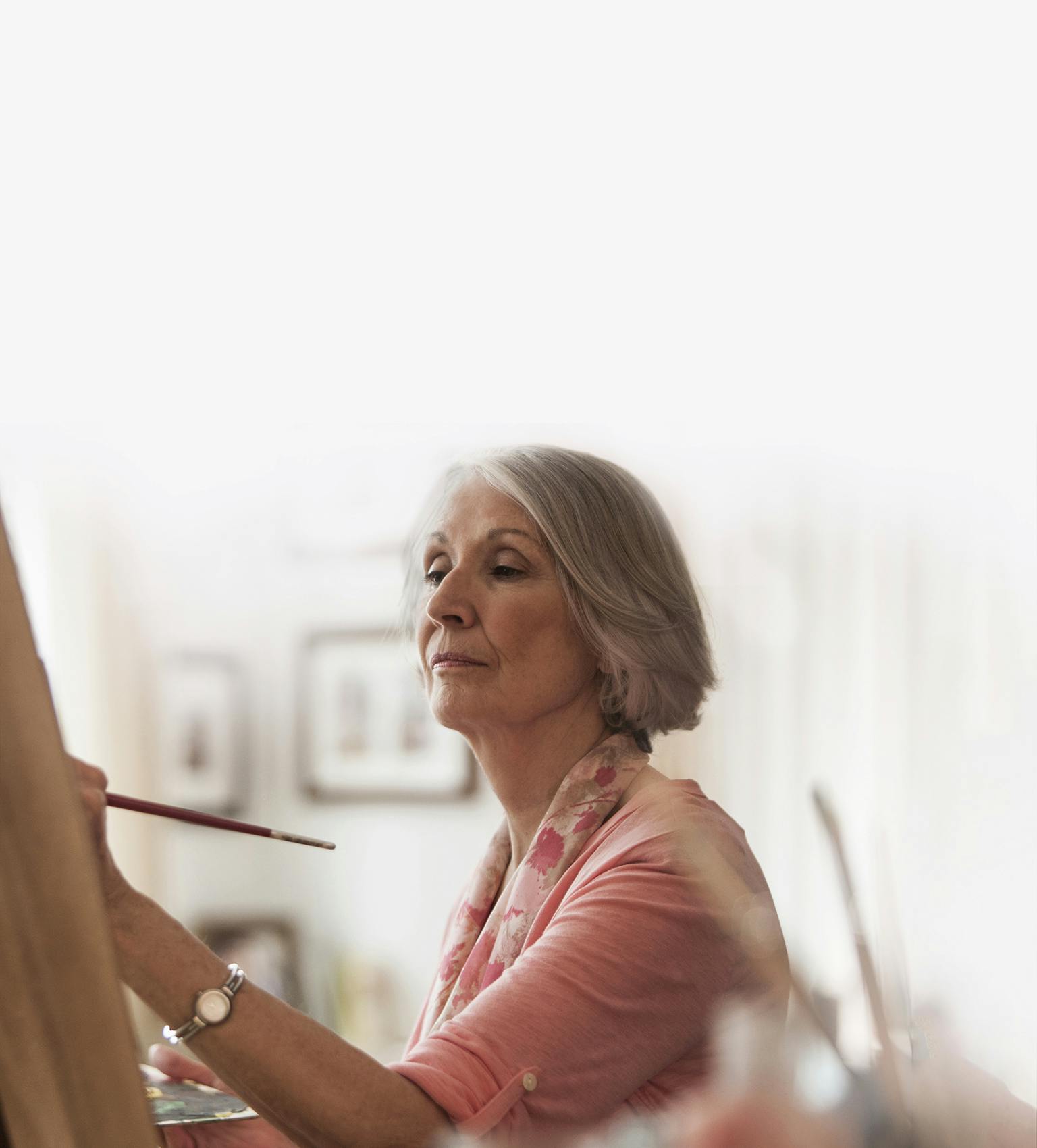 Femme d'âge mûr qui peint une toile sur un chevalet