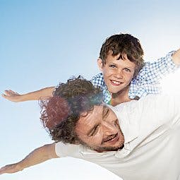 Father carrying son on back
