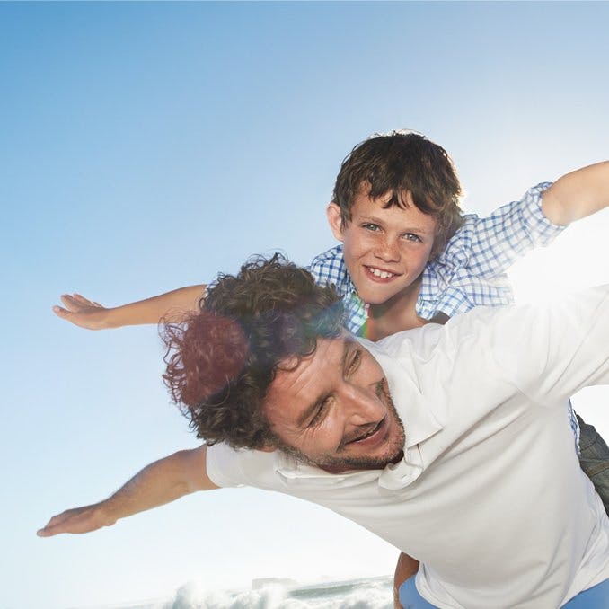 Father carrying son on back
