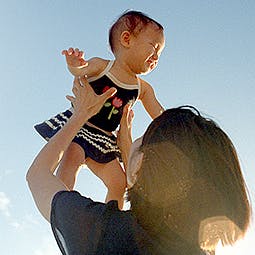 Γυναίκα που σηκώνει ψηλά ένα μωρό
