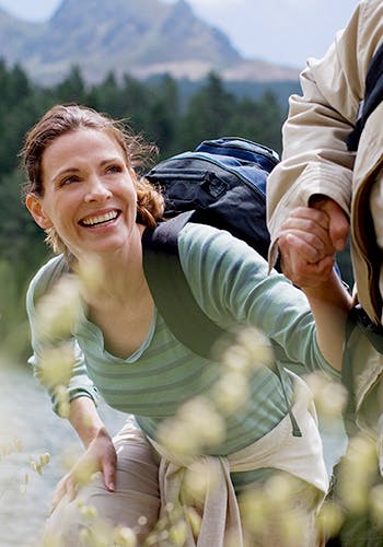A hiker getting help to climb from another hiker