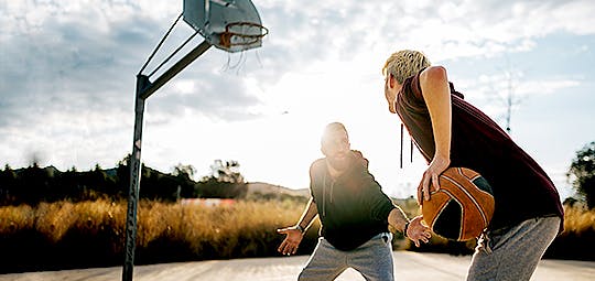 Photograph of two men playing basketball