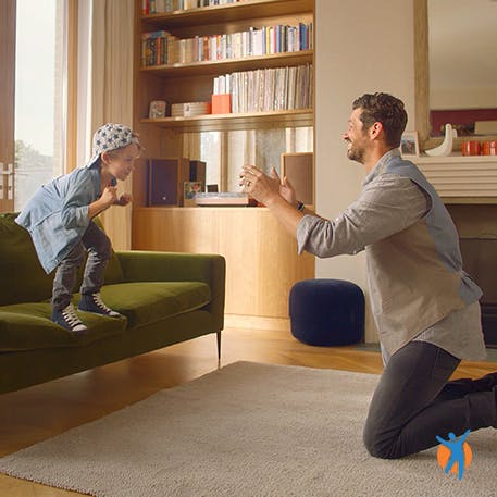 Father and son playing in lounge, thanks to Voltarol pain relief range