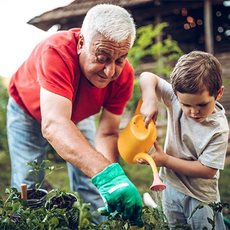 man and kid watering plants