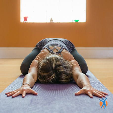 Close up of a woman in seated yoga pose for relieving back pain