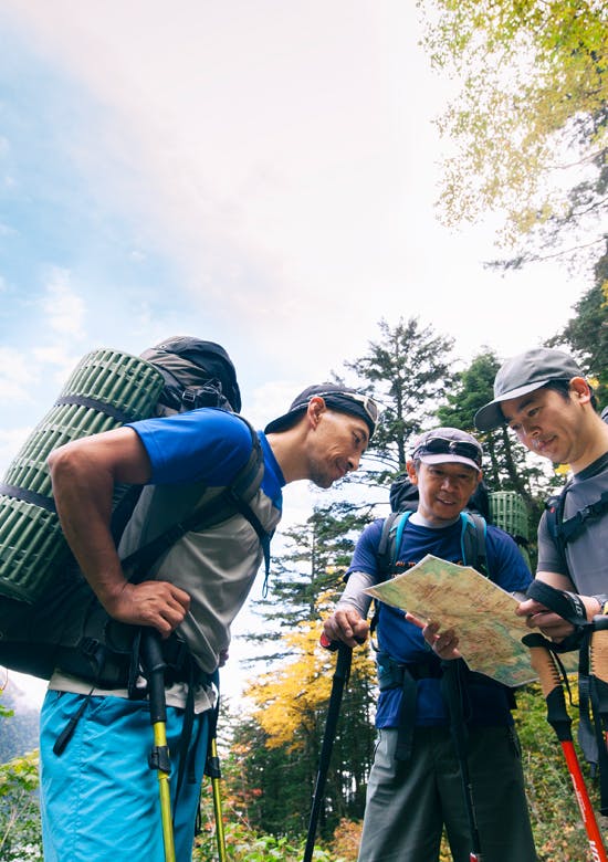 登山中に地図を見る3人の男性 登山中に地図を見る3人の男性