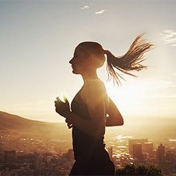 Ćwiczenia i Twoje ciało - biegnąca dziewczyna na tle zachodzącego słońca