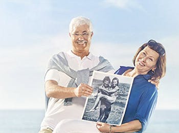 Zatrzymaj chwile - Starsza para pozuje trzymając zdjęcie z ich młodości