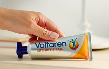 una mano sosteniendo el tubo de Voltaren Arthritis Pain
