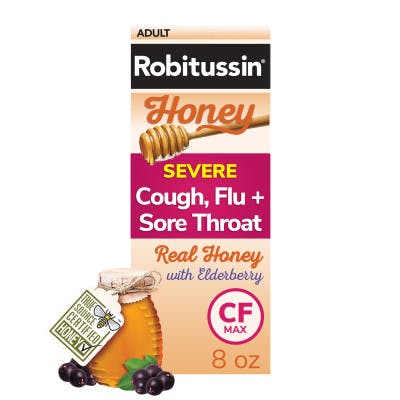 una caja colorida de Robitussin Honey para adultos con el resfriado y gripe con un tarro de miel con sabor a baya del saúco