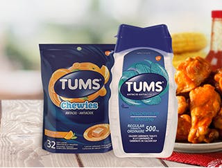 Bag of Tums Chewies & a bottle of Tums Regular Strength next to spicy chicken wings