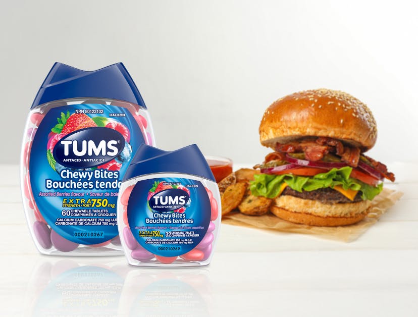 Tums Chewy bites in different sizes next to hamburger and fries Tums Chewy bites in different sizes next to hamburger and fries