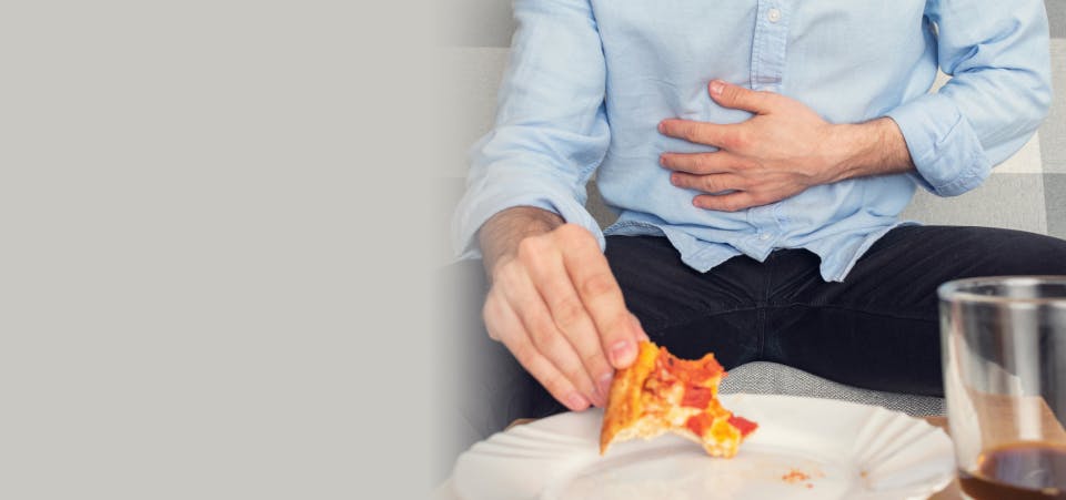 Man with pizza clutching his stomach