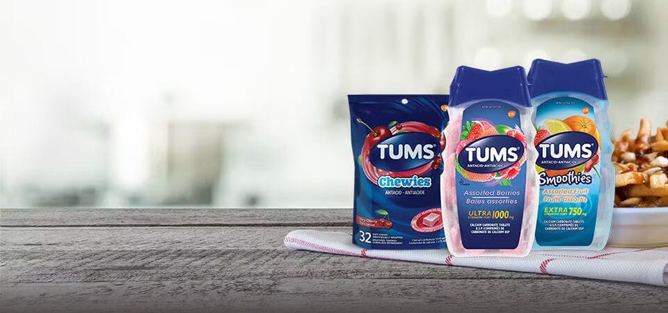 Three TUMS products lined up beside a plate of poutine