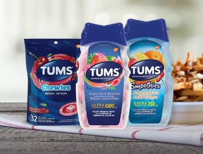 Three TUMS products lined up beside a plate of poutine