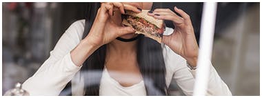 Jeune femme mangeant un sandwich santé