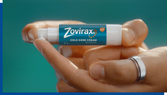 Person with ring on finger holding Zovirax Cold Sore Cream pump Person with ring on finger holding Zovirax Cold Sore Cream pump