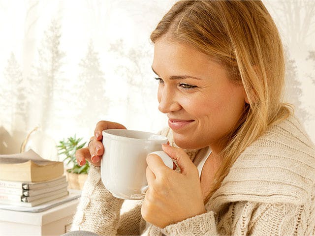 woman smiling while having tea