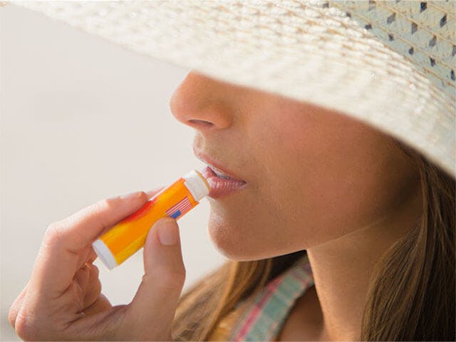 Woman applying lip balm Woman applying lip balm