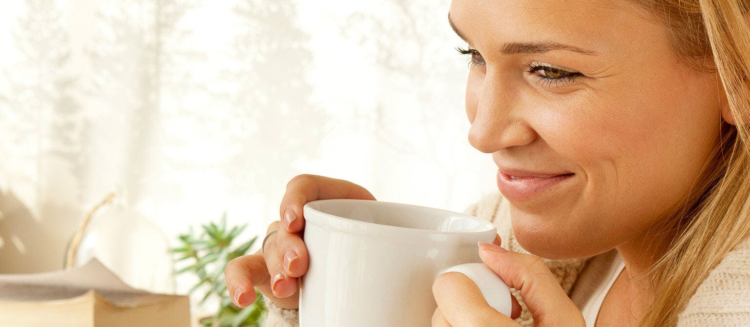 woman smiling while having tea
