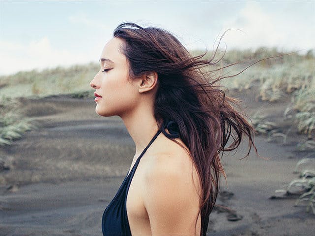 Woman closing her eyes with wind in her hair