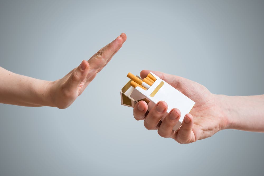 Hand refusing cigarette offer Hand refusing cigarette offer