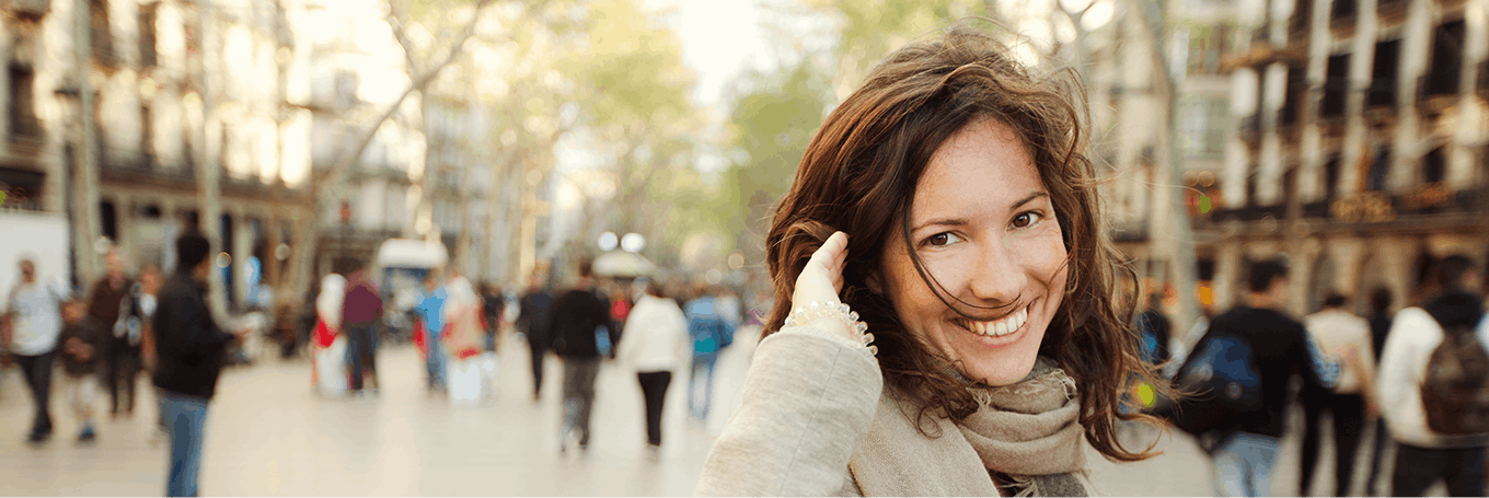 Woman smiling at the camera with hand in her hair